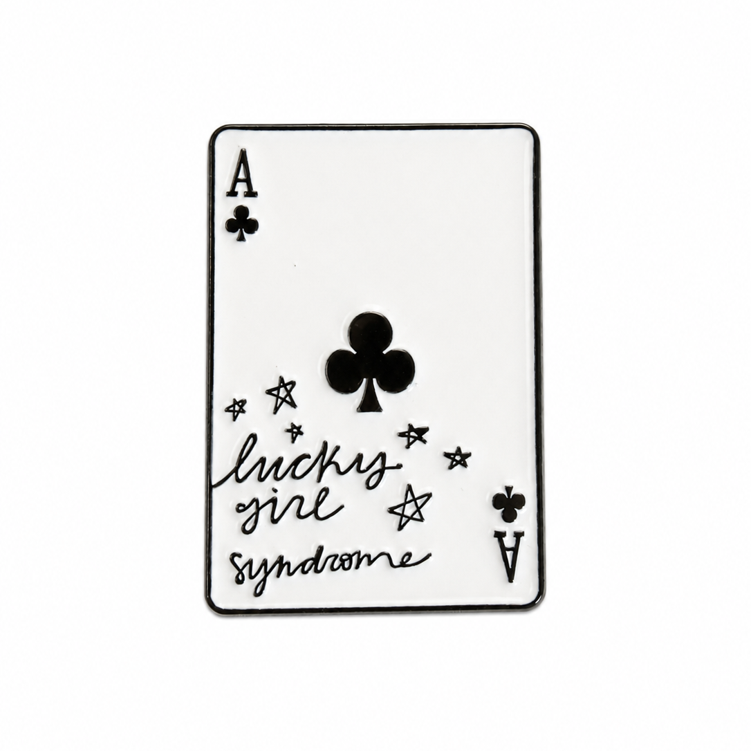 A single playing card styled like an Ace of Clubs card with the phrase 'lucky girl syndrome' in black script, shown on a plain white background.